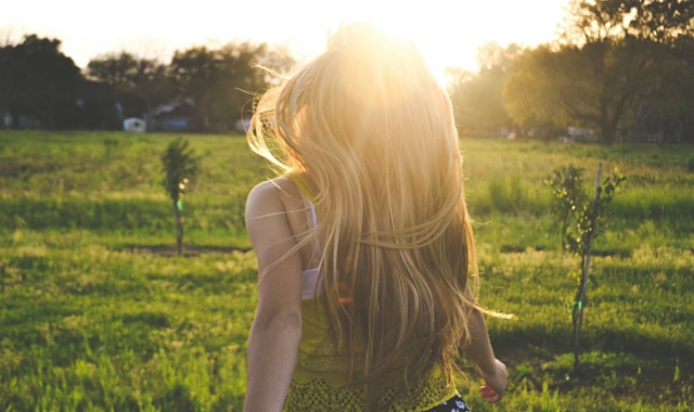 new year reflections for 2016 girl facing sunset in green field